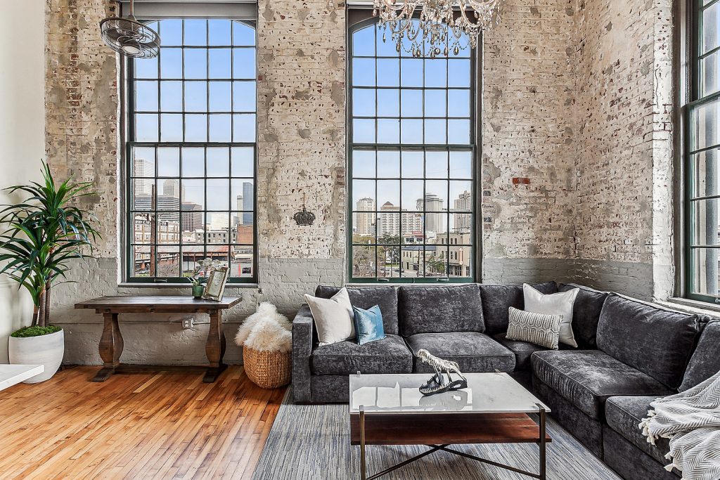 Living room with exposed brick and textures framing downtown city views of New Orleans