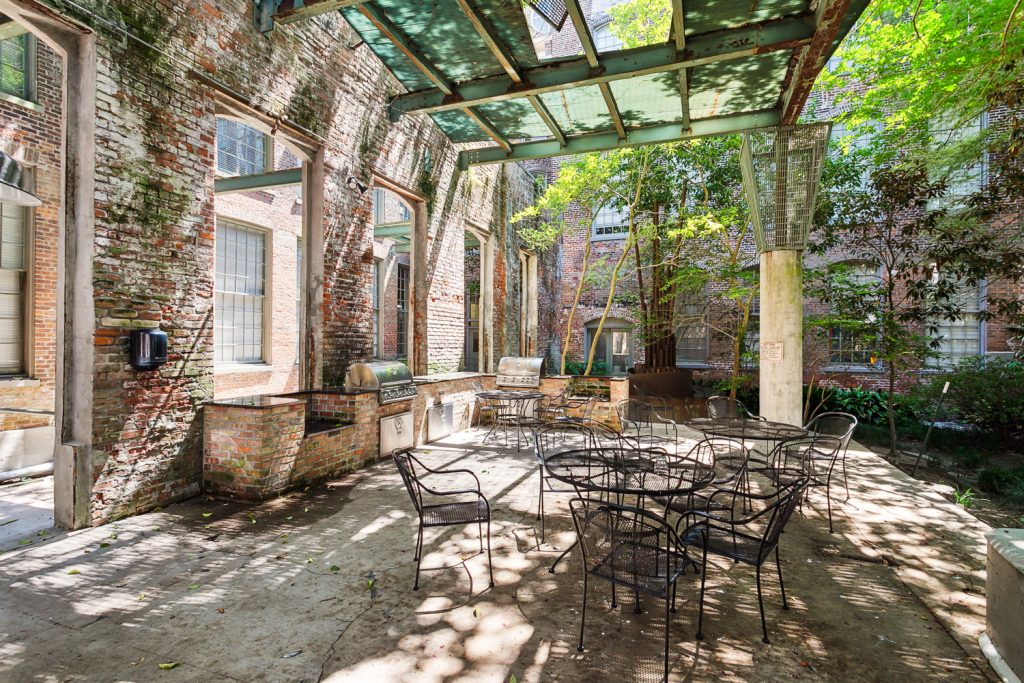 Awning-covered courtyard patio and outdoor kitchen at Cotton Mill Condominiums New Orleans